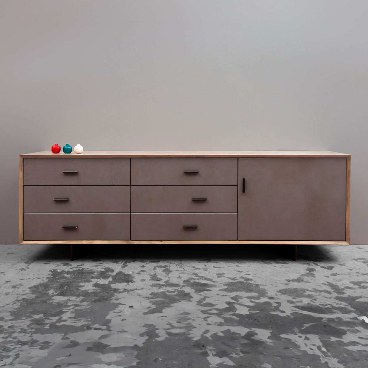 A SENTIENT Murlough luxury credenza with a minimalist white design and distinctive curved wooden side panels, staged against an industrial backdrop.